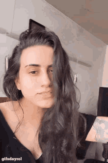 a woman with a tattoo on her arm is taking a picture of herself