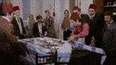 a group of people gathered around a table with plates of food