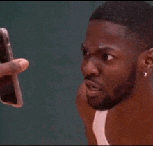 a man is taking a picture of another man with his cell phone .