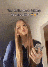 a woman with long blonde hair is holding a cell phone and talking to a police officer .
