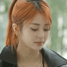 a woman with red hair wearing a pearl necklace and earrings