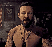 a shirtless man with a beard and tattoos on his arms is standing in front of a wall .