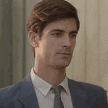 a man in a suit and tie is looking down