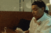 a woman in a white shirt is sitting at a table in a diner .