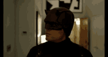 a man in a daredevil costume stands in front of a sign that says a