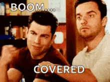 two men are sitting next to each other and one of them is covering the other 's shoulder .