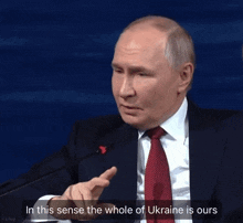 a man in a suit and tie says in this sense the whole of ukraine is ours in front of a microphone
