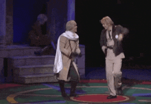 a couple of men are dancing on a stage in a play .