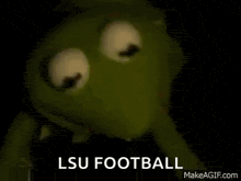 kermit the frog is holding a syringe in his mouth and saying `` lsu football '' .