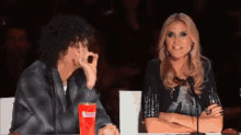 a man and a woman are sitting at a table with a cup that says coca cola on it .