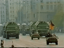 a group of military vehicles are driving down the street