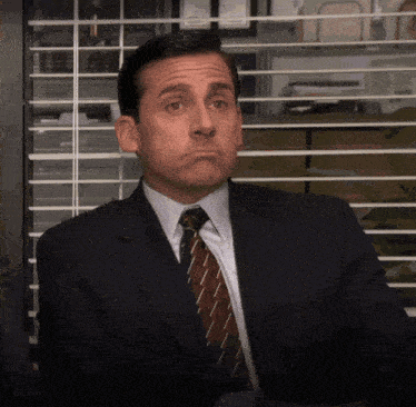 a man in a suit and tie making a face