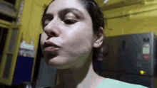 a close up of a woman 's face in front of a yellow wall .