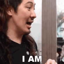 a man with long hair and a beard is saying i am .
