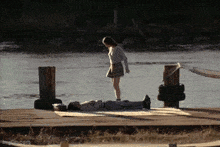 a girl is standing next to a man laying on the ground
