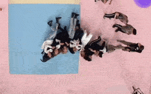 a group of people laying on top of each other on a pink surface