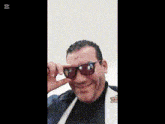 a man is wearing sunglasses and making a funny face