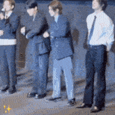 a group of men in suits and ties are standing in a line