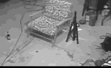 a black and white photo of a chair and a bottle of beer