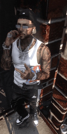 a man with a tattoo on his arm is wearing a white tank top and a black hat with the letter c on it