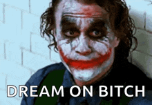 a close up of the joker 's face with the words dream on bitch written below it