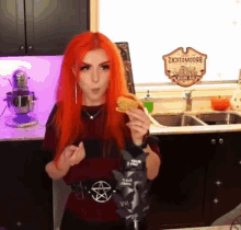 a woman with red hair is holding a bag of potato chips in front of a sign that says broomstick