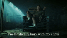 a man sitting in a chair with the words " i 'm terrifically busy with my ennui " below him