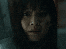 a close up of a woman 's face with a tear coming out of her nose