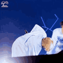 a person is laying on a bed with a blue background .