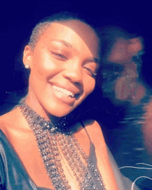 a woman wearing a necklace of beads is smiling for the camera