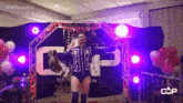 a wrestler is walking through a ring with balloons and a sign that says cap