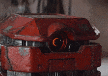 a close up of a red object with a glowing eye