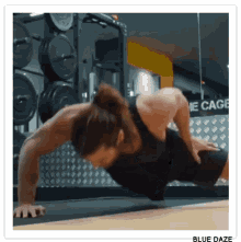 a man is doing push ups in front of a sign that says " the cage "