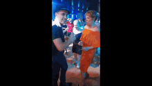 a woman in an orange dress is dancing on a dance floor with other people .