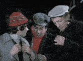 three men wearing hats and scarves are standing together