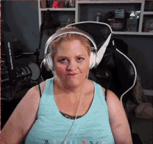 a woman wearing headphones and a tank top that says ' a ' on the front