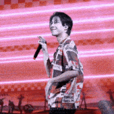 a man wearing a shirt that says " the temple " is holding a microphone