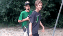 two boys are standing next to each other on a sandy beach .