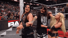 a man and two women in a wrestling ring with the word ram on the wall