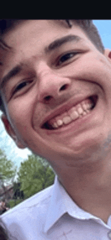 a close up of a young man 's face smiling with his mouth open .