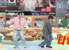 two men are dancing in front of a sign that says " round "