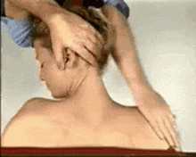 a man is getting a neck massage from a nurse .