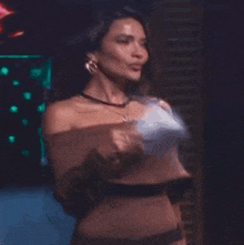 a woman in a brown off the shoulder top is dancing on stage .