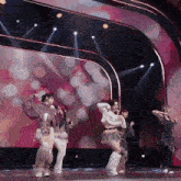 a group of women are dancing on a stage and one of them is wearing a furry skirt