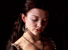 a close up of a woman 's face with earrings and a necklace