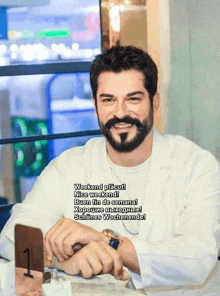 a man with a beard and mustache is sitting at a table with a number 1 on it