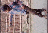 a man in a plaid shirt is laying on his back with his legs crossed .