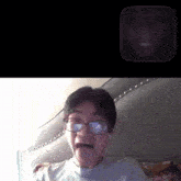 a man wearing glasses is making a funny face in a video call