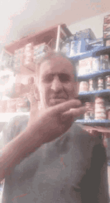 a man is making a funny face in front of a store shelf with a can of coca cola on it