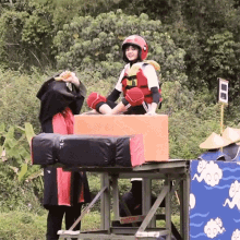 a person wearing a red helmet is sitting on a box with a sign that says ' a ' on it